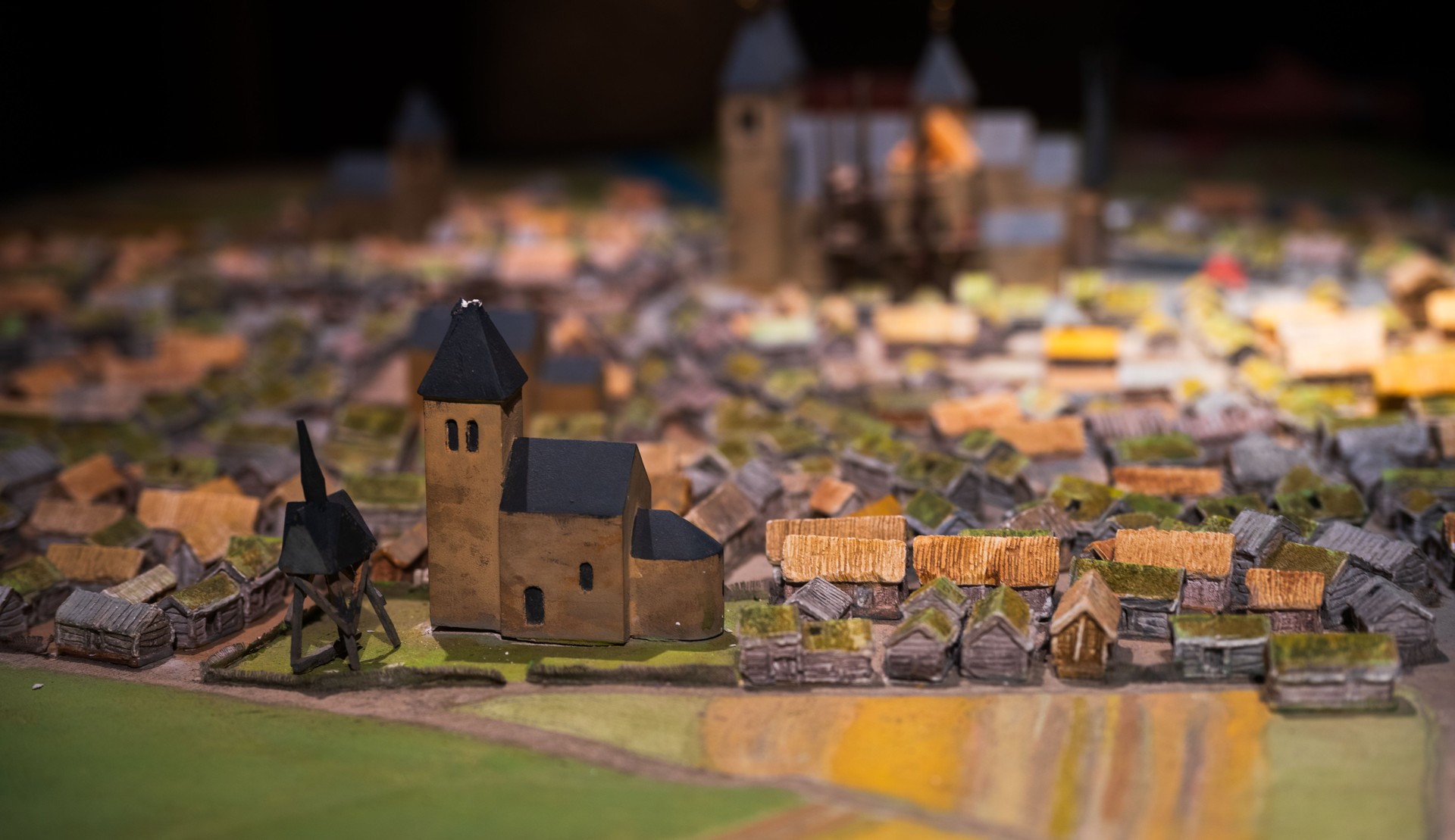 Miniature medieval village model with central church.